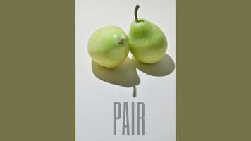 Two pears (the fruit) with the incorrect spelling p-a-i-r written below. 